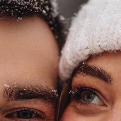 two men are looking into the camera with snow on their heads