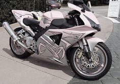 a silver and black motorcycle parked on the sidewalk