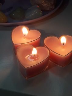 three heart shaped candles sitting on top of a table