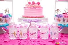 pink table with cake and water bottles on it