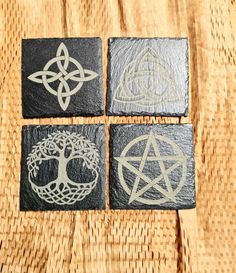 four black and white stone coasters with silver celtic designs on them, sitting on a woven table cloth