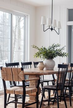 a dining room table with chairs and a potted plant on top of the table