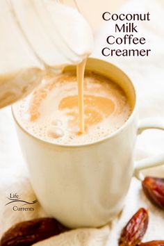 a person pouring milk into a cup filled with coffee creamer next to dried dates