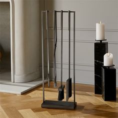 two candles are sitting on the floor next to each other in front of a fireplace