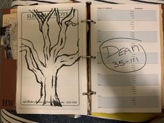 an open notebook with a drawing of a tree on the front and back pages in it