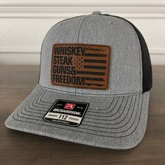 Whiskey, Steak, Guns & Freedom Patch Hat.Specifications: 🧢 Richardson original 112 trucker; adjustable for the perfect fit 🎩 60/40 cotton/polyester blend for comfort 📏 One size fits most 🏷️ Expertly laser engraved leatherette patch design 📦 Ships in 2 to 3 business days from our Orlando Studio Care Instructions: 🚫 Do not wash; spot clean only Please Note: 🌈 Colors may vary from photos based on your viewing screen. This funny hat is a unique and entertaining gift for fathers, embracing their dual role with humor. Leather Hat Patch Ideas, Whiskey Steak, Creek Ideas, Orlando Studios, Funny Trucker Hat, Leather Patch Hat, Engraved Tumblers, Engraving Ideas, Laser Engraved Leather