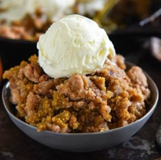 a close up of a bowl of food with ice cream on top and an orange in the background