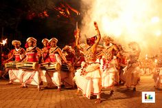 a group of people that are standing in the street with some kind of fire behind them