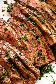 grilled steaks with herbs and seasoning on a white plate, ready to be eaten