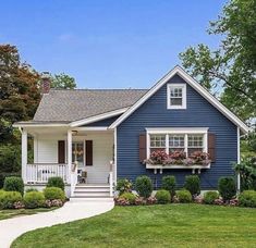 a blue house with white trim and red shutters on the front door is shown