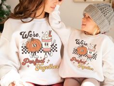 "Celebrate the magic of the fall season with our adorable Matching Mommy and Me Pumpkin Spice Fall Sweaters! Designed to capture the joy of togetherness, these sweaters feature the charming slogan \"We're a Perfect Match\" in a retro groovy font, accompanied by the cute graphic of a pumpkin and a pumpkin spice latte as retro mascot characters. If you're a fan of pumpkin spice lattes and love coordinating outfits with your little one, this Mommy And Me Fall collection is an absolute must-have. Whether it's for a Thanksgiving gathering or a casual day at the pumpkin patch, these Halloween Matching sweaters are sure to become your new fall favorites. These Pumpkin Sweatshirts are more than just a seasonal fashion statement; they represent the bond between mom and child. They make a delightful Playful White Sweatshirt For Fall, Matching Cotton Sweatshirt For Fall, Cotton Fall Sweatshirt, Playful Letter Print Sweatshirt For Fall, Playful Letter Print Sweater For Fall, White Family Matching Sweatshirt For Fall, Fun White Sweater For Fall, White Fun Sweater For Fall, Fall Crew Neck Sweatshirt