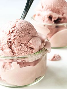 two bowls filled with pink ice cream on top of a white table next to each other