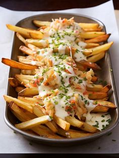 french fries covered in ranch dressing and garnished with parmesan cheese on top