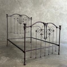 an antique iron bed frame with scroll work