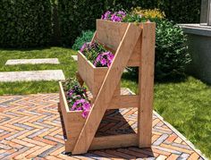 a wooden planter sitting on top of a brick patio next to flowers and grass