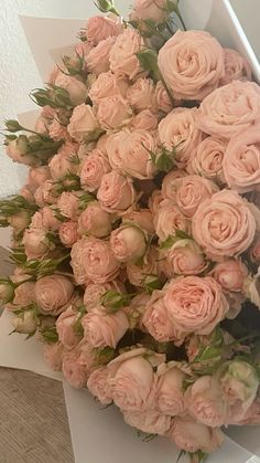 a bouquet of pink roses sitting on top of an envelope