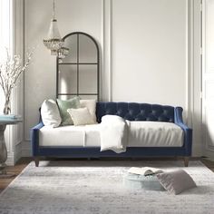 a living room with a blue couch and white rug