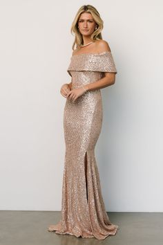 a woman in a gold sequin gown posing for the camera with her hands on her hips