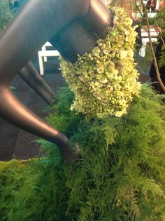 a sculpture is covered in green plants and grass