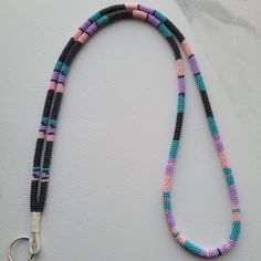 a multicolored beaded lanyard on a white surface