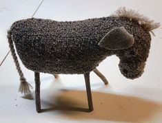 a toy horse made out of yarn sitting on the floor