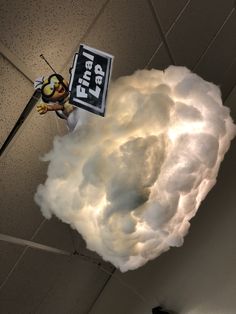 a cloud with a sign hanging from it's side on the ceiling in an office building