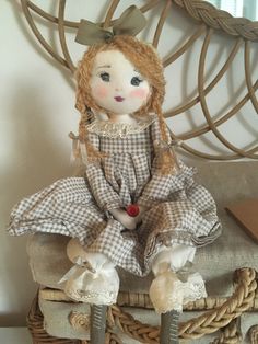 a doll sitting on top of a wicker chair