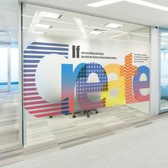 an office with large colorful letters on the wall and glass doors that let in light