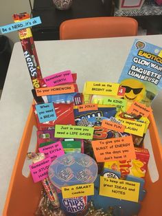 a basket filled with lots of candy sitting on top of a white table next to an orange chair