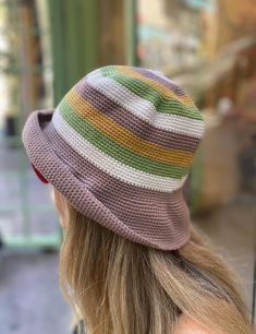 a woman with blonde hair wearing a multicolored knitted hat on her head