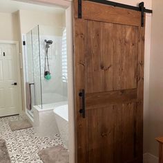 an open door leading to a bathroom with a bathtub and shower