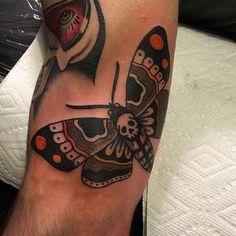 a tattoo with a butterfly on it's arm and a skull in the middle