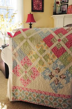 a living room with a large quilt on the couch