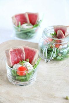 watermelon and lettuce salad in small glass bowls on a wooden board