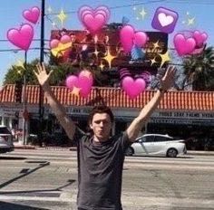 a man standing on the street holding up pink hearts