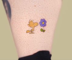 a woman's leg with a tattoo of a dog and flowers on the side