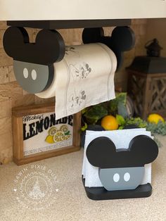 a mickey mouse napkin holder is on the counter next to a kitchen towel dispenser