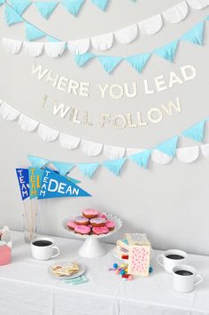 a table topped with cake and cupcakes next to a banner that says where you lead i will follow