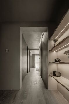 an empty hallway with shelves and lights on the wall