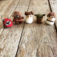 five small stuffed animals sitting on top of a wooden table