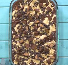 a chocolate and peanut butter ice cream dessert in a glass dish on a blue background