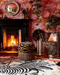 a living room filled with furniture and a fire place in the fireplace surrounded by wallpaper