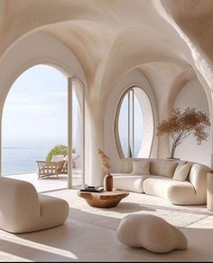 a living room filled with lots of white furniture and large round windows overlooking the ocean