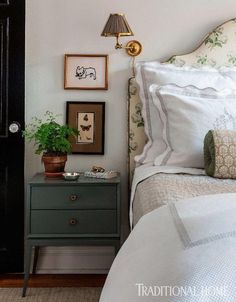 a bed room with a neatly made bed and some pictures on the wall above it