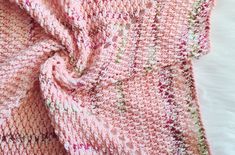 a close up of a pink knitted blanket