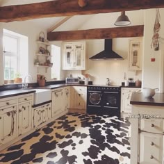 a kitchen with black and white cow print flooring on the floor next to an oven