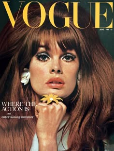 a woman with long red hair and flower in her hand on the cover of a magazine