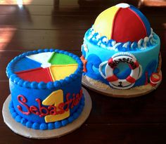 two cakes decorated to look like beach toys on a wooden table with sunlight coming through the window