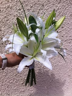 a bouquet of white flowers in someone's hand