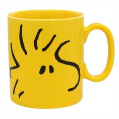 a yellow coffee mug with a black drawing on it